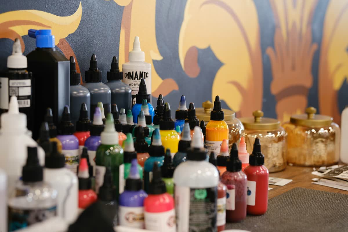 Ink bottles lined up in front of the studio's mural